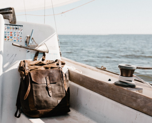 Backpack on a sailboat ready for remote work travel with ocean view