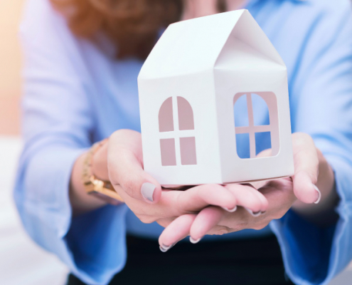South African expat holding a model house representing tax residency