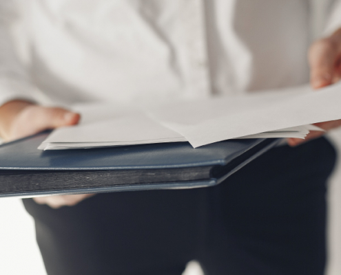 Person holding a file with documents, symbolizing the process of confirming SARS Non-Resident Tax Status for expatriates.