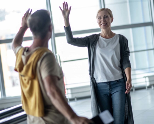 South African expats greeting at airport upon return, symbolizing SARS expat repatriation process.