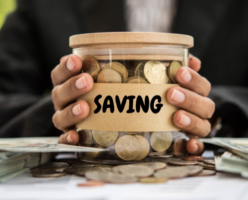 Saving money in a jar with coins