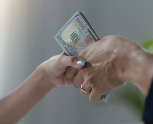 Person handing over money symbolizing tax payments and financial responsibility